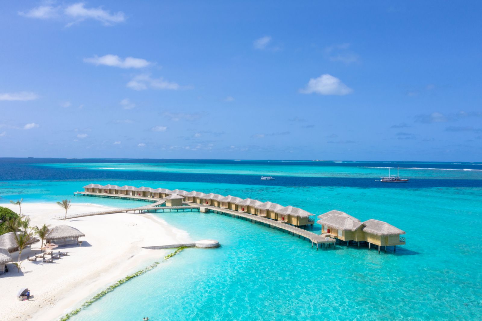 Overwater villas arcing across a turquoise Maldives lagoon